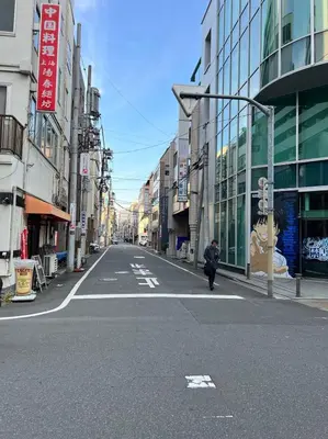 an empty city street with a person walking down the street at Ueno358 in Tokyo