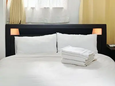 a pile of towels sitting on top of a bed at \u6dfa\u590f\u9928Asakakan2 in Tokyo