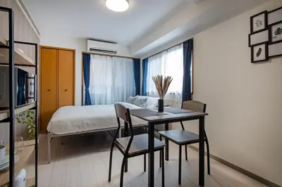 a bedroom with a bed and a table and chairs at CraftFlat Numabukuro 305, uphill residence in Tokyo