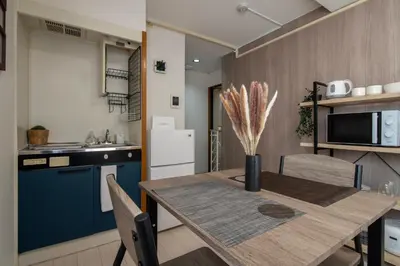 a kitchen with a wooden table and a blue refrigerator at CraftFlat Numabukuro 305, uphill residence in Tokyo