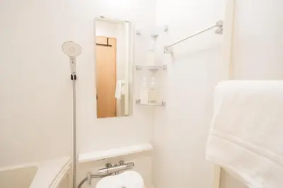 a white bathroom with a shower and a mirror at m1 \u30db\u30c6\u30eb in Tokyo