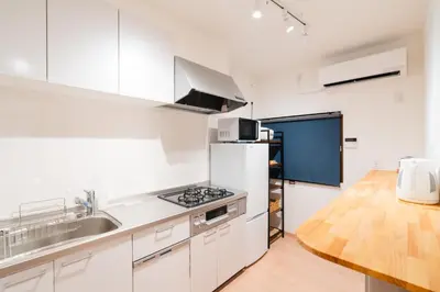 a white kitchen with a sink and a refrigerator at m1 \u30db\u30c6\u30eb in Tokyo