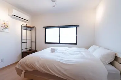 a bedroom with a large white bed with a window at m1 \u30db\u30c6\u30eb in Tokyo