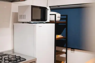a microwave on top of a refrigerator in a kitchen at m1 \u30db\u30c6\u30eb in Tokyo