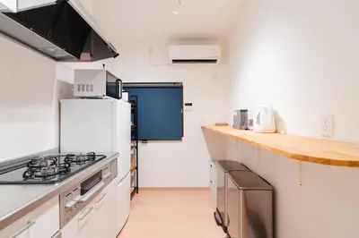 a kitchen with white counters and a white refrigerator at m1 \u30db\u30c6\u30eb in Tokyo