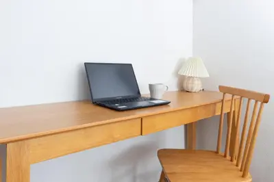 a laptop computer sitting on top of a wooden desk at Hanna Inn SHIBUYA 501 in Tokyo