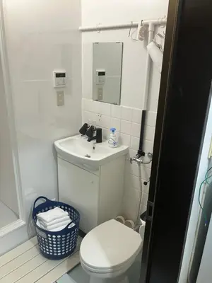 a white bathroom with a toilet and a sink at Hanna Inn SHIBUYA 501 in Tokyo