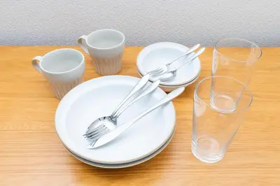 a table with plates and forks and glasses on it at Hanna Inn SHIBUYA 501 in Tokyo