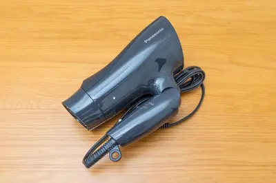 a black hair dryer sitting on a wooden table at Hanna Inn SHIBUYA 501 in Tokyo
