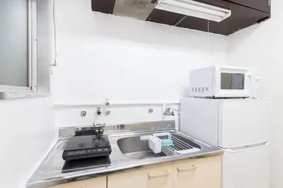 a kitchen with a sink and a microwave at Hanna Inn SHIBUYA 102 in Tokyo