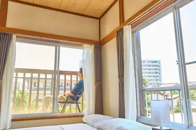 a person sitting in a chair looking out of a window at Stay as Local mizue in Tokyo