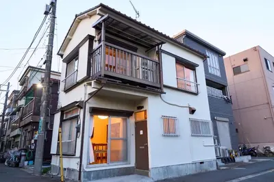 a white house with a balcony on a street at Stay as Local mizue in Tokyo