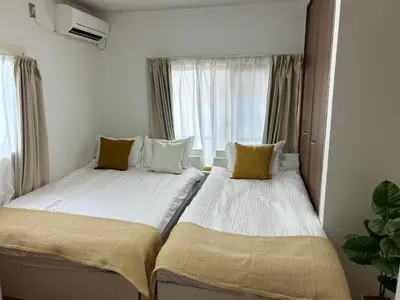 two beds in a small room with a window at Mori Hotel \u897f\u6c60\u888b in Tokyo