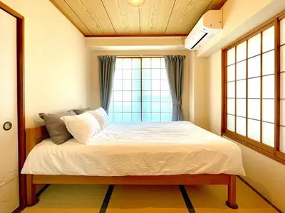 a bedroom with a bed in front of a window at \u30a8\u30fc\u30c7\u30eb\u30ef\u30a4\u30b9 Edelweiss in Tokyo