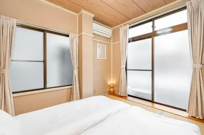a bedroom with a bed and large windows at Mori House \u8d64\u7fbd\u4e00\u6237\u5efa in Tokyo