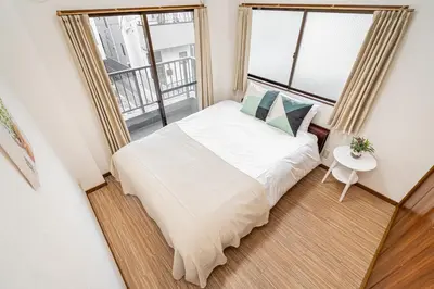 a small bedroom with a bed and two windows at Mori House \u8d64\u7fbd\u4e00\u6237\u5efa in Tokyo