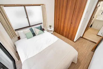 a bedroom with a large white bed and a window at Mori House \u8d64\u7fbd\u4e00\u6237\u5efa in Tokyo