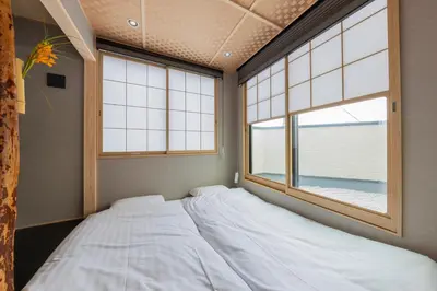 a bedroom with a bed and two windows at \u4eac\u6708Kyogetsu in Tokyo