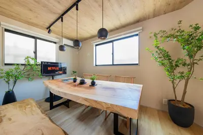 a large wooden table in a room with windows at \u4eac\u6708Kyogetsu in Tokyo