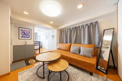 a living room with a couch and a table at \u6771\u771f\u30d3\u30eb2\u968e \u7b39\u585a\u99c5\u304b\u3089\u5f92\u6b694\u5206 in Tokyo