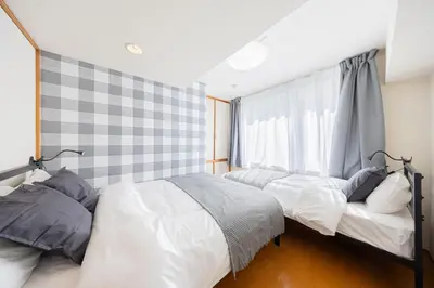 a bedroom with two beds and a window at \u6771\u771f\u30d3\u30eb2\u968e \u7b39\u585a\u99c5\u304b\u3089\u5f92\u6b694\u5206 in Tokyo