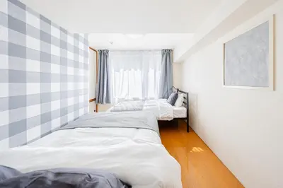 two beds in a room with a window at \u6771\u771f\u30d3\u30eb2\u968e \u7b39\u585a\u99c5\u304b\u3089\u5f92\u6b694\u5206 in Tokyo
