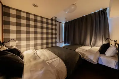 a bedroom with two beds in front of a window at \u6771\u771f\u30d3\u30eb2\u968e \u7b39\u585a\u99c5\u304b\u3089\u5f92\u6b694\u5206 in Tokyo