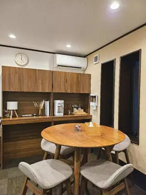 a table and chairs in a room with a clock at Komorebi Rill \u6d45\u8349 in Tokyo