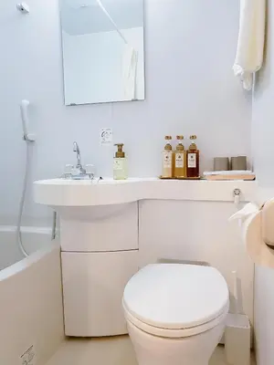 a white bathroom with a toilet and a sink at Komorebi Rill \u6d45\u8349 in Tokyo