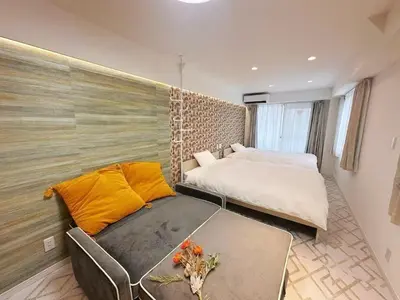 a bedroom with a bed and a couch with a table at Louis House\u5927\u585a\u897f \u6c60\u888b2\u5206 in Tokyo