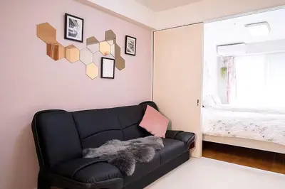 a black leather couch in a room with a window at Louis House\u5927\u585a\u897f \u6c60\u888b2\u5206 in Tokyo
