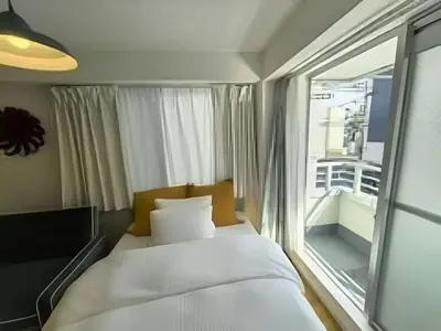 a bed in a room with a large window at Louis House\u5927\u585a\u897f \u6c60\u888b2\u5206 in Tokyo