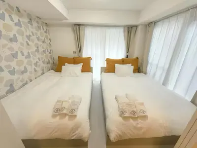 two beds sitting next to a window in a room at Louis House\u5927\u585a\u897f \u6c60\u888b2\u5206 in Tokyo
