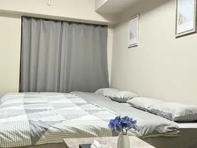 a bedroom with two beds and a vase with flowers on a table at \u6c60\u888b Energy CA0 a9 in Tokyo