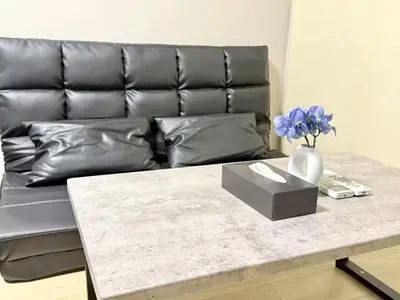 a leather couch with a table and a vase with flowers at \u6c60\u888b Energy CA0 a9 in Tokyo
