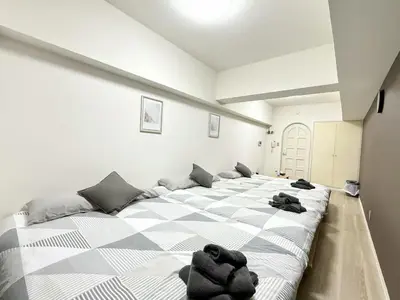 a large bed in a white room with black towels on it at Ikebukuro IVY House Ao6 in Tokyo