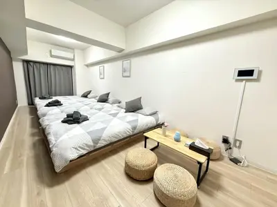 a bedroom with a large bed and two stools in it at Ikebukuro IVY House Ao6 in Tokyo