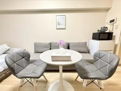 a living room with a table and two chairs at Ikebukuro Warm\u30cf\u30a6\u30b9306 in Tokyo