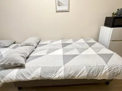 an unmade bed in a bedroom with at Ikebukuro Warm\u30cf\u30a6\u30b9306 in Tokyo