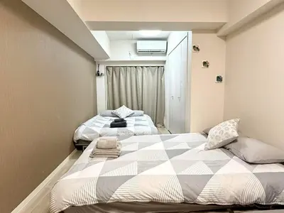 a bedroom with two beds and a window at Ikebukuro Warm\u30cf\u30a6\u30b9306 in Tokyo
