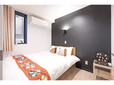 a bedroom with a bed and a black wall at Tokyo Biyori Hotel - Vacation STAY 07403v in Tokyo