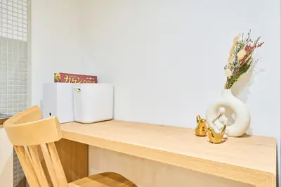 a desk with a white vase and flowers on it at HouseHotel\u897f\u6c60\u888b in Tokyo