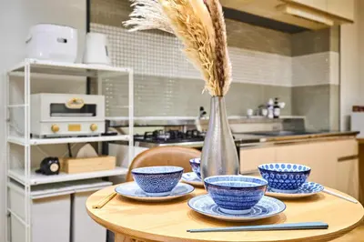 a table with blue and white bowls and a vase at HouseHotel\u897f\u6c60\u888b in Tokyo