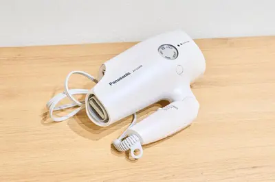 a white hair dryer sitting on a wooden table at HouseHotel\u897f\u6c60\u888b in Tokyo