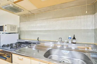a kitchen with a stainless steel sink and a refrigerator at HouseHotel\u897f\u6c60\u888b in Tokyo