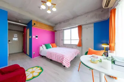 a colorful bedroom with a bed and a table at Stayloop\u30b9\u30ab\u30a4\u30c4\u30ea\u30fc in Tokyo