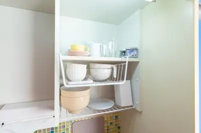 a white cabinet with bowls and other kitchen utensils at Stayloop\u30b9\u30ab\u30a4\u30c4\u30ea\u30fc in Tokyo