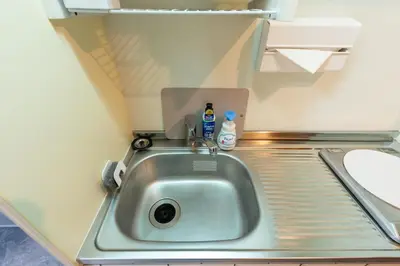 a sink in a small kitchen with two bottles on it at Stayloop\u30b9\u30ab\u30a4\u30c4\u30ea\u30fc in Tokyo