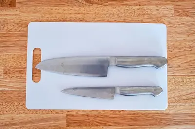 two knives sitting on top of a white cutting board at Unite Stay Gyotoku in Tokyo
