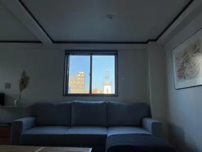 a living room with a blue couch and a window at Asakusa Loft in Tokyo
